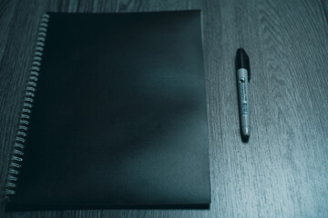 Large notebook and black marker in candlelight