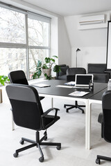 Black table, armchairs and stationery prepared for business meeting in modern conference hall