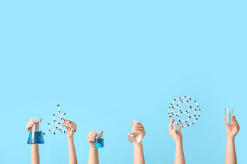 Female hands holding molecular models and filled flasks with measuring cup on blue background....