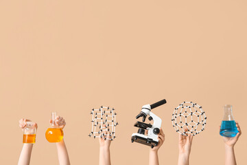 Female hands holding molecular models with microscope, filled flasks and bottle on beige...