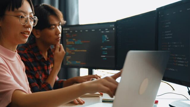 Slow motion back end software developer engineer for computer programming working together on debugging writing computing code, solving complex algorithms display on monitor in office. Burgeoning