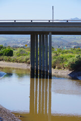 Freeway bridge reflection on water surface