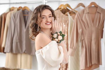 Beautiful young happy woman with boutonniere preparing for prom in wardrobe