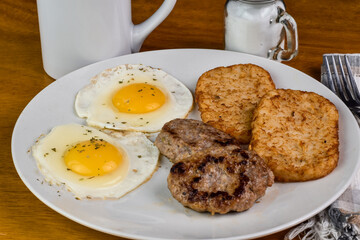 two fried eggs  with hash browns and sausages