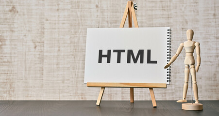 There is notebook with the word HTML. It is an abbreviation for Hyper Text Markup Language as eye-catching image.