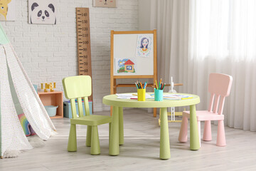 Table with chairs and blackboard in children's room