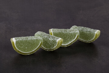 Vegan dessert. Marmalade "Lime slices". Close-up. Dark gray background	