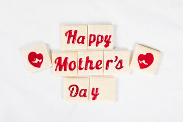 Mother's Day dessert. Cute Delicate square shortbread cookies with red marmalade filling in the shape of the words happy mother's day and heart. White background. Top view