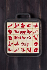 Holiday square cookies with marmalade filling in a thematic form, happy mother's day, mom, flower, butterfly, mother and child, hearts. On a wooden plate. Dark background. Rustic style. Mothers Day