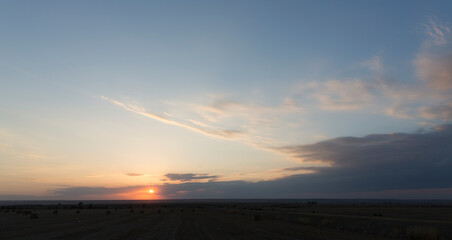 Landscape with bloody sunset. Panorama. Tragic gloomy sky. The last flashes of the sun on the storm clouds.