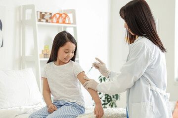 Little Asian girl receiving vaccine at hospital