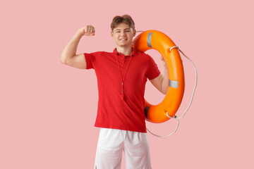 Male lifeguard with lifebuoy ring on pink background
