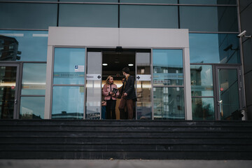 Two business professionals engaged in a serious conversation about their new project strategy while standing on office steps.