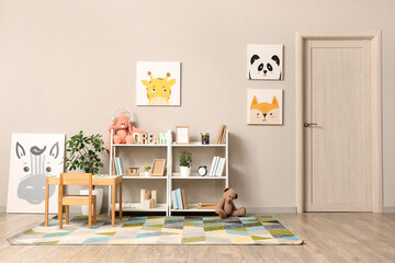 Interior of children room with toys, pictures, table and shelving units