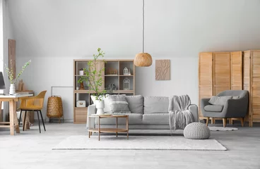 Rucksack Interior of stylish living room with cozy sofa, coffee table and blooming tree branches in vase © Pixel-Shot