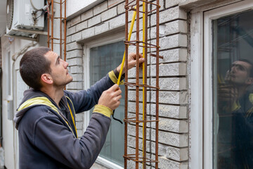Worker in the construction site making reinforcement metal framework for concrete pouring