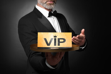 Man holding tray with VIP sign on black background, closeup