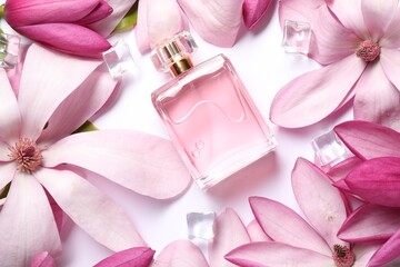 Beautiful pink magnolia flowers, bottle of perfume and ice cubes on white background, flat lay