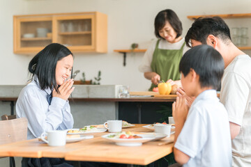 ダイニングで朝食をとる・朝ごはんを食べる家族・ファミリー（いただきます・挨拶・合掌）
