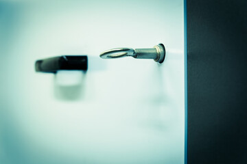 Focused closely on a key inserted into a lock, the blurred background featuring a door handle...