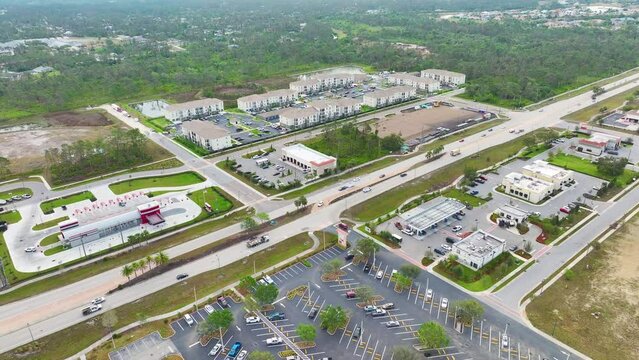 Shopping plaza stores and American wide highway with many driving cars in North Port, Florida. View from above of USA transportation infrastructure