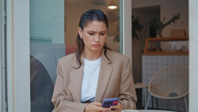 Elegant girl reading smartphone message at cafe terrace close up. Confused lady 
