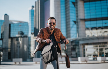 Confident male businessperson enjoying a ride on an electric scooter in an urban setting, carrying...