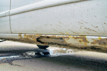 Close-up of a car threshold rotted from reagents