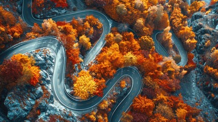 Top-down view of a spiraling mountain road with autumn colors