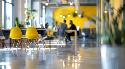 Bright splashes of yellow and green provide a pop of color in the defocused background image of the open concept workspace. The blurred team huddled together in conversation bring .