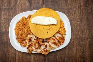 Traditional Colombian breakfast - Grilled chicken, arepa, cheese, fried egg and reheated beans with rice