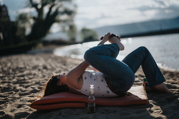 A peaceful scene as a young woman enjoys yoga on a sunlit beach, capturing the essence of...