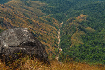Naklejka premium A rocky hillside with a river running through it
