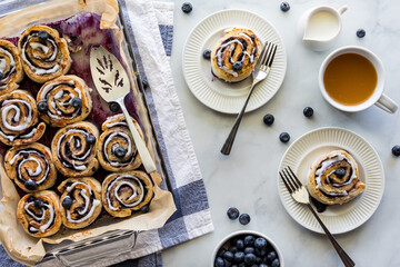 Two servings of homemade blueberry cinnamon buns served with tea.