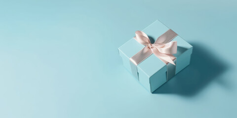 Gift box, top view. Elegant blue present box with white silk bow on a blue pastel background, copy space. Beautiful Background for greeting card for Birthday, Mother's Day, Wedding, Valentine's Day
