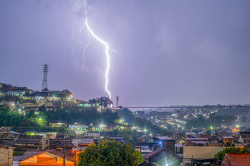 Semarang, Indonesia - Circa 2024 : Lightning strike over the civilian house with darkclouds and...