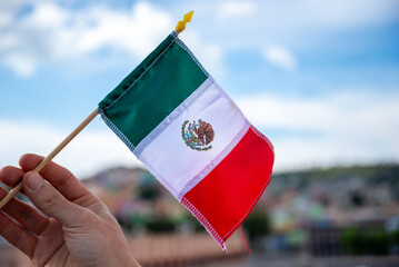 Proud Display of the Mexican Flag with a Scenic Town Backdrop