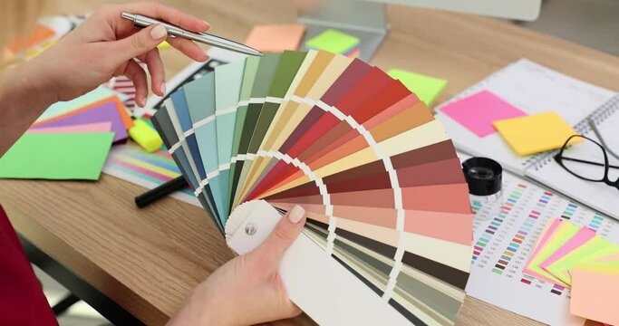 Woman selects paint color from color palette for interior design project
