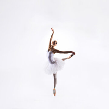 Ballet dancer isolated on white. Beautiful ballerina performing in studio.