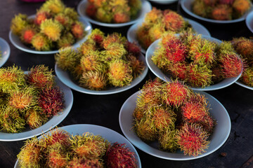 Ready-to-eat rambutans placed in several blue plastic dishes.