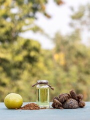 Amla Oil and Powder or Indian Gooseberry Fruit or Amla Candy Isolated on Wooden Table with Copy Space, Also Known as Emblica Myrobalan or Phyllanthus Emblica in Vertical Orientation