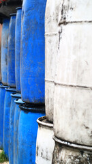 Stacks of drums of cooking oil in front of a kiosk.