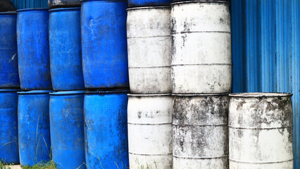 Stacks of drums of cooking oil in front of a kiosk.