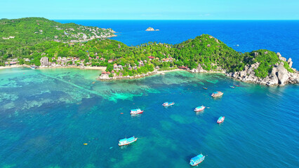 Explore the serene beauty of an island oasis from above as tourists snorkel amidst azure waters,...