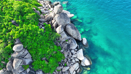 Majestic rocky shores meet lush forests against the backdrop of crystal blue waters, a captivating...
