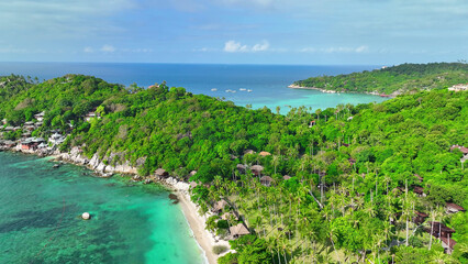 A mesmerizing coastline draped in emerald foliage, hosting a picturesque resort amidst azure...