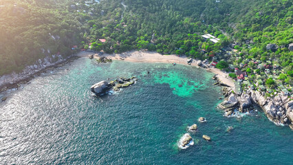 Serene green sandy shores cradle a stunning resort, embraced by crystal-clear waters, offering an idyllic escape into nature's embrace. Aerial drone. Koh Nangyuan, Southern Thailand. Sea background.  