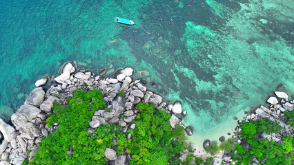 Explore a mesmerizing tropical haven as a drone captures tourists snorkeling in azure waters,...