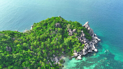 Emerald forests fringe the rugged coastline, adorned with distinctive rock formations, while...