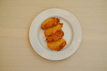 Corn croquettes on a white plate on a wooden table